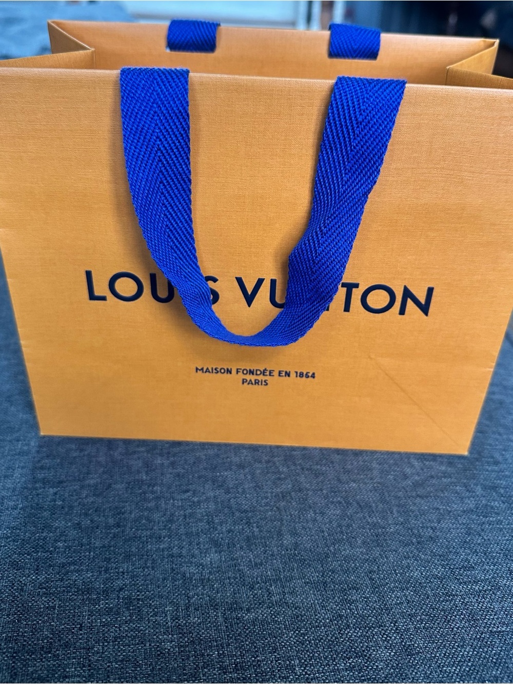 Louis Vuitton Orange Shopping Bag with Blue Handles and Black Logo
